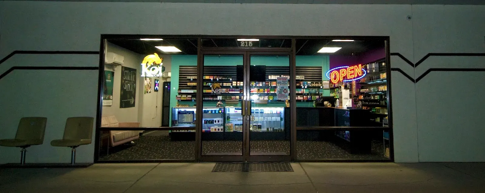 Exterior of Crush Vapor & Smoke Shop at night with neon signs.
