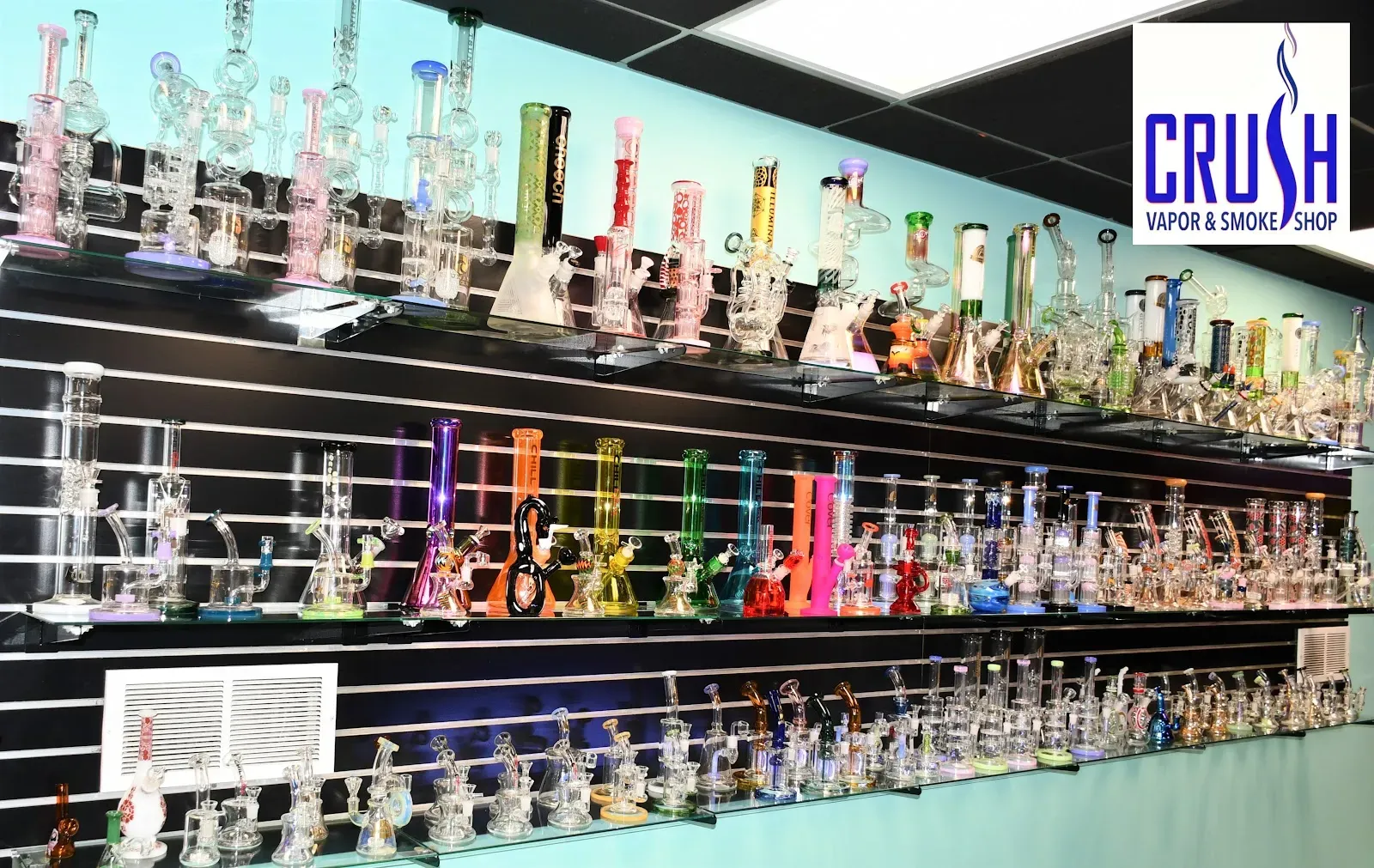 Wall display of various glass bongs and smoking accessories.