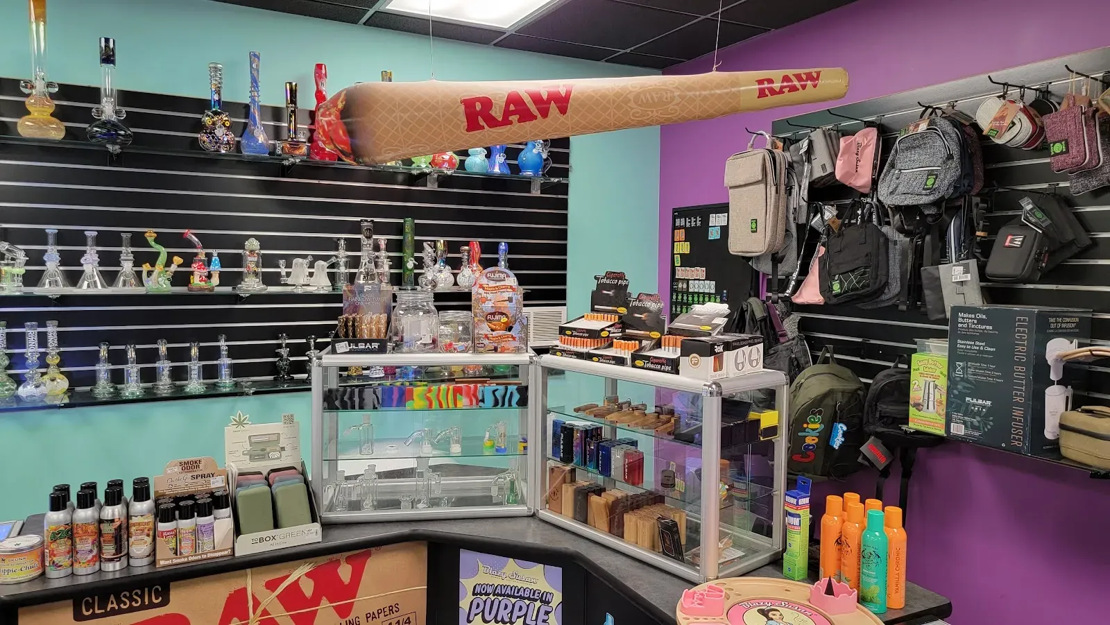 Interior view with glass displays, a large RAW joint, and bags.