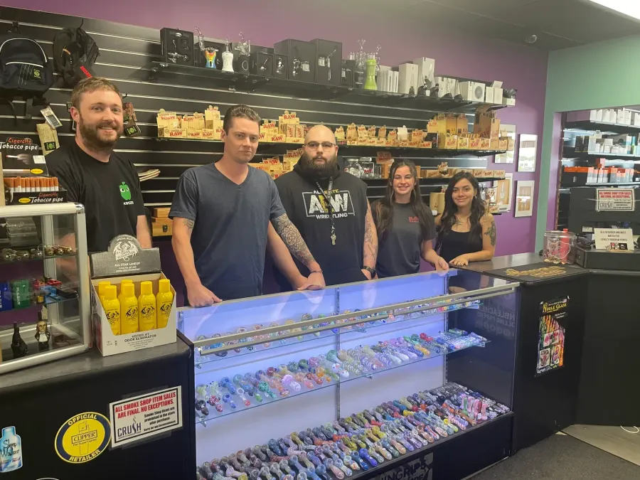 Five staff members smiling behind the counter of the shop.